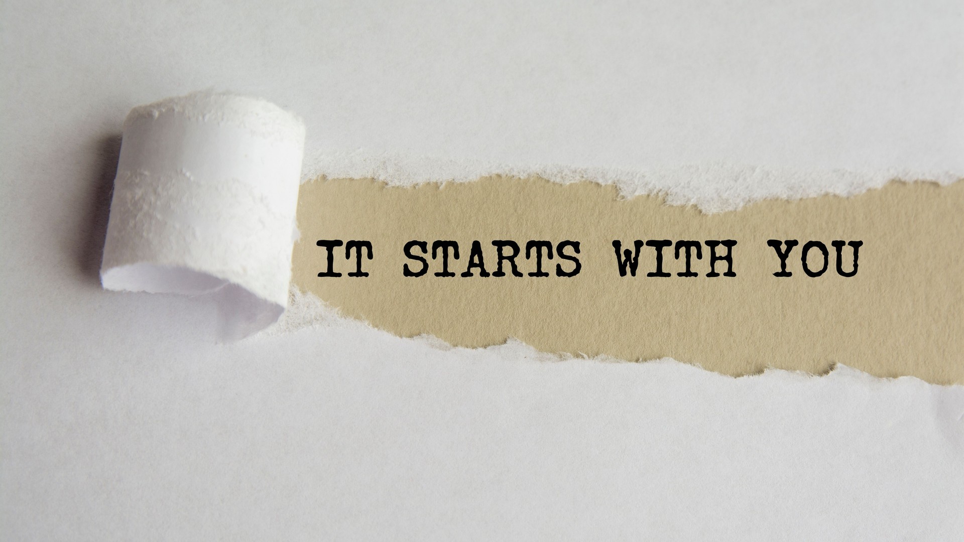 IT STARTS WITH YOU. words. text on grey paper on torn paper background
