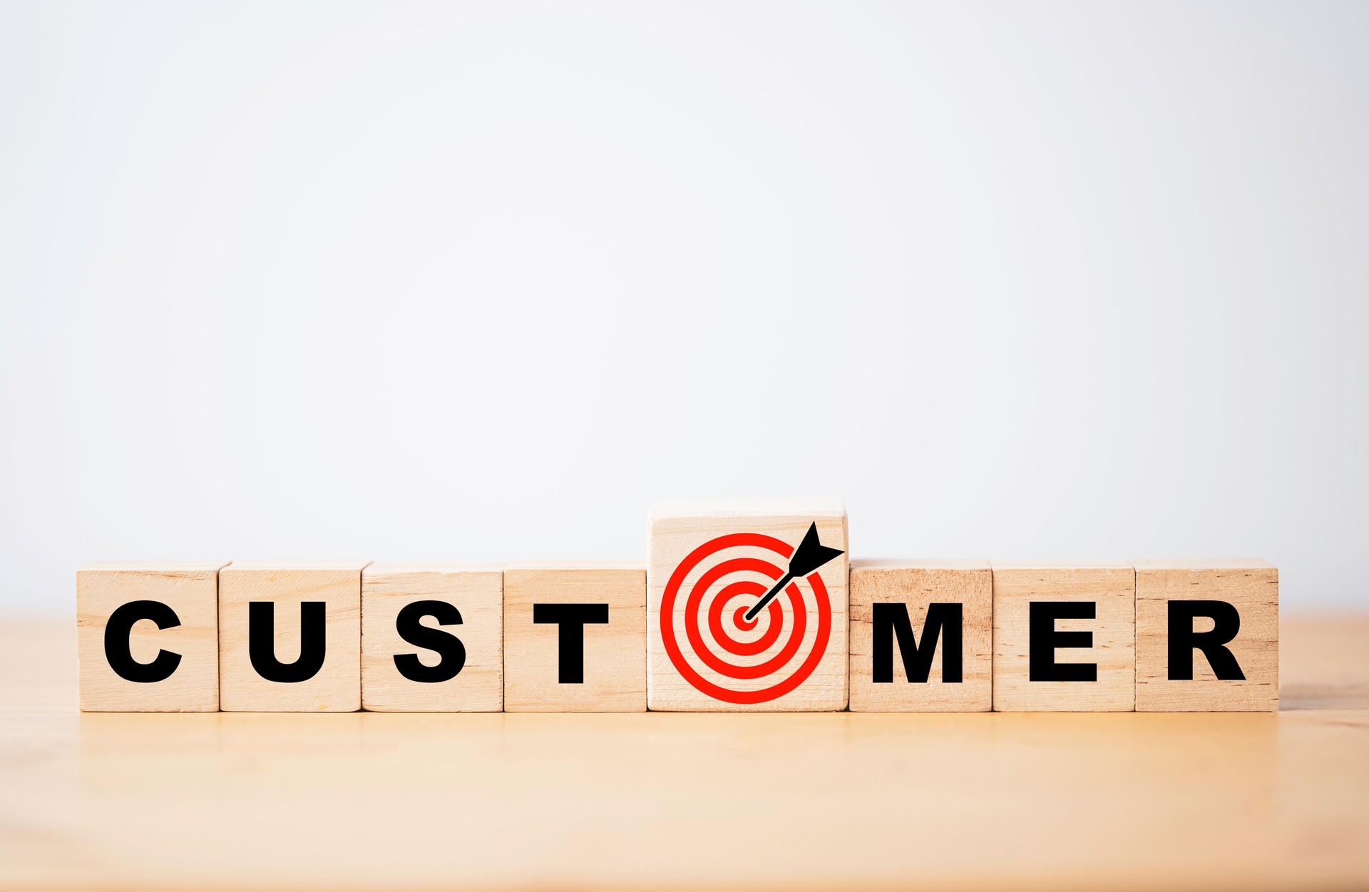 customer wording on wooden cube block with red target board with arrow drawing for business customer focus and target concept.